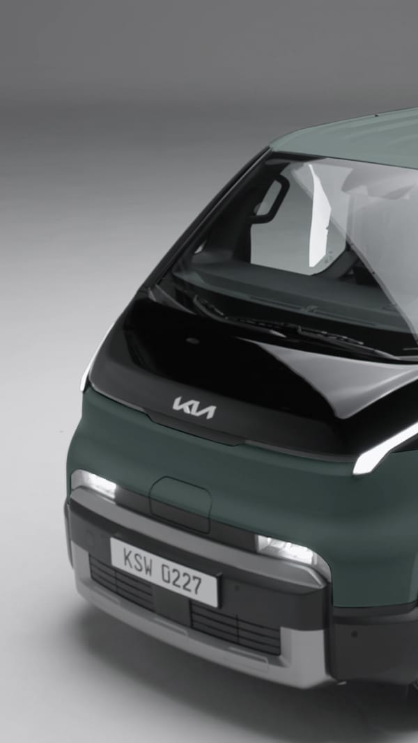 Der Kia PV5 WAV ist in der vorderen Dreiviertelansicht vor grauem Hintergrund zu sehen.