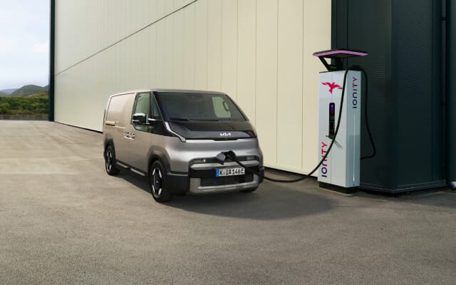 Frontansicht des Kia PV5 WAV, angeschlossen an eine Ladestation, mit sichtbarer Antriebsstrang-Überlagerung